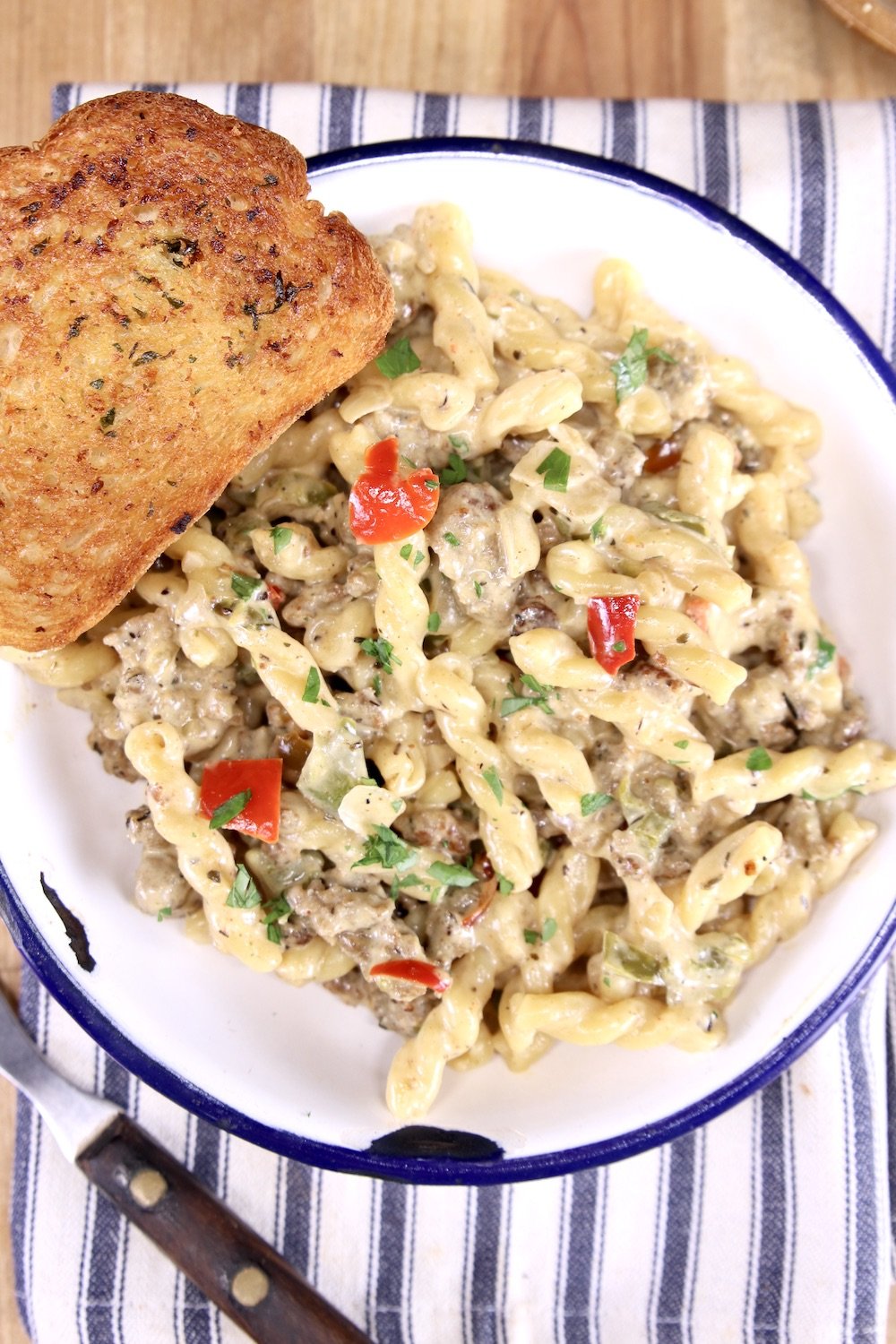 bowl of sausage pasta and garlic bread