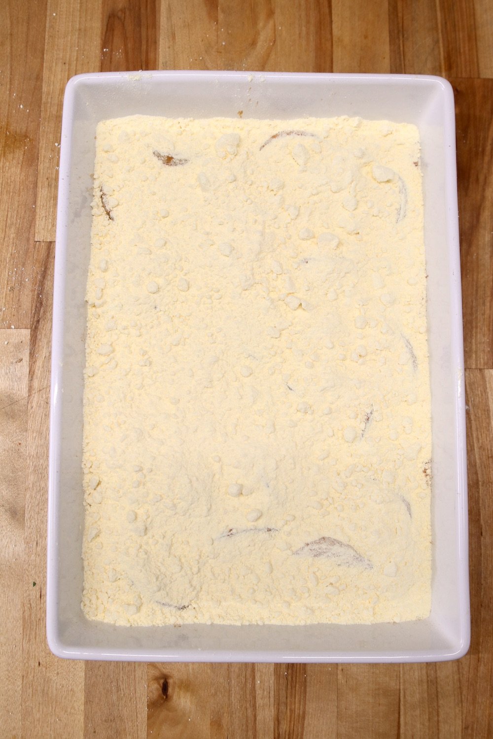 cake mix sprinkled over peaches in cake pan