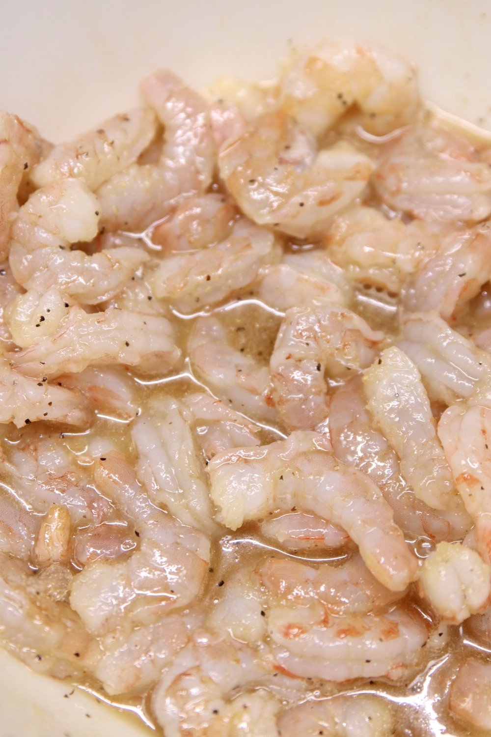 marinating shrimp in a bowl