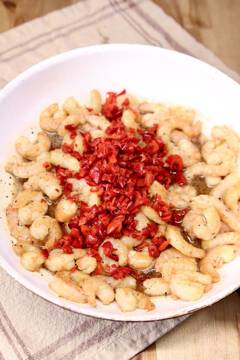 skillet with shrimp and diced red bell peppers