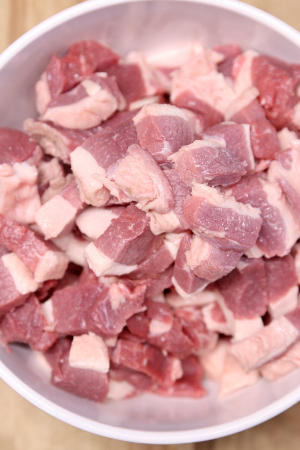 chunks of pork shoulder in a bowl for making sausage
