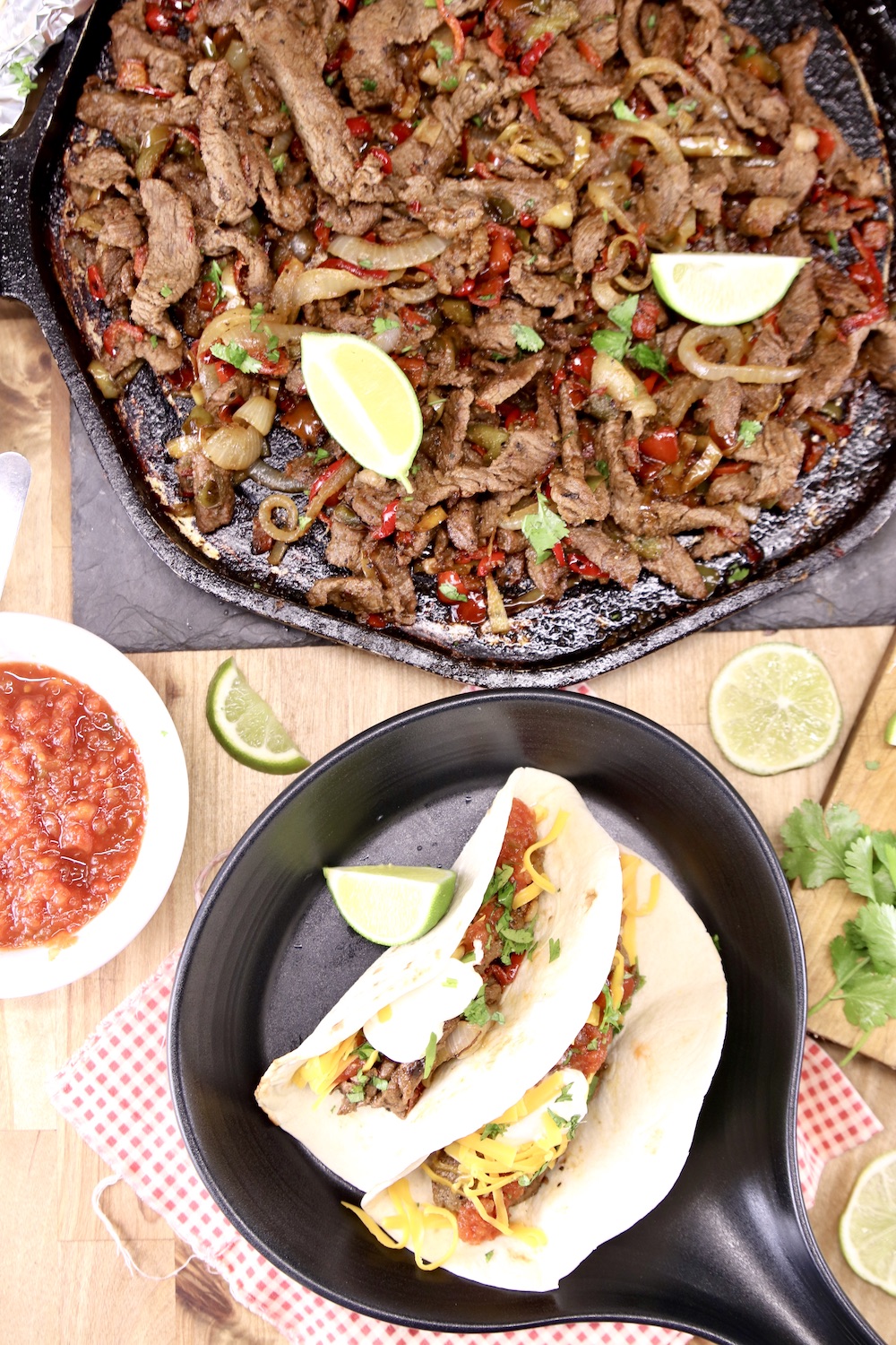 Platter with steak fajitas, bowl with 2 steak fajitas in tortillas