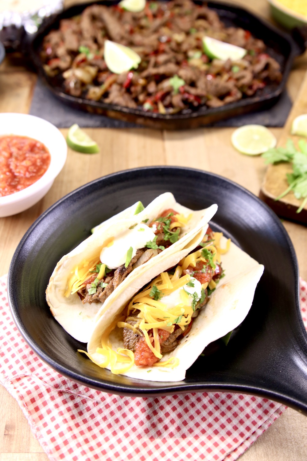Steak fajitas with cheese, sour cream and salsa