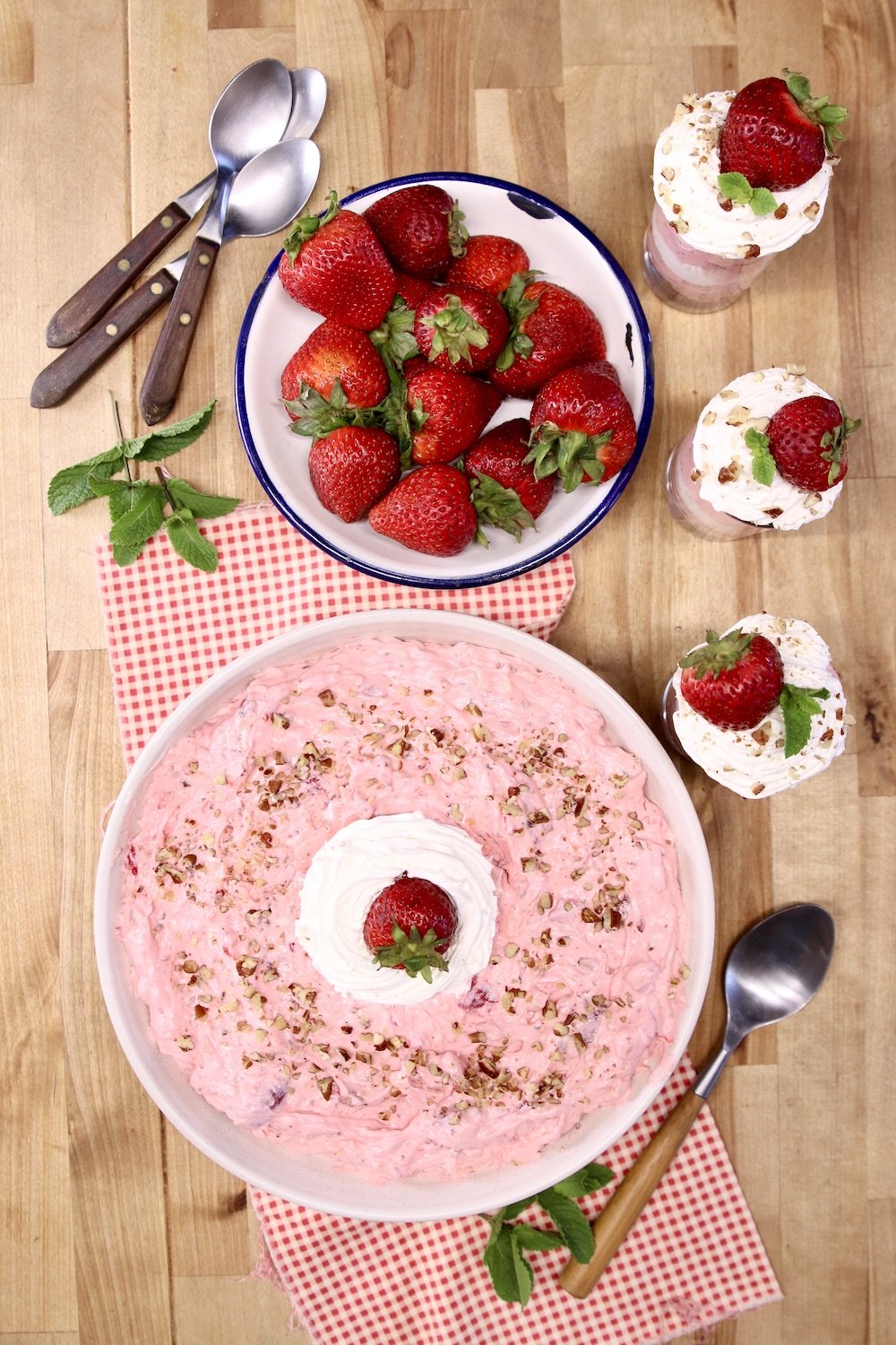 Strawberry Fluff in a bowl, bowl of strawberries and 3 dessert glasses of fluff