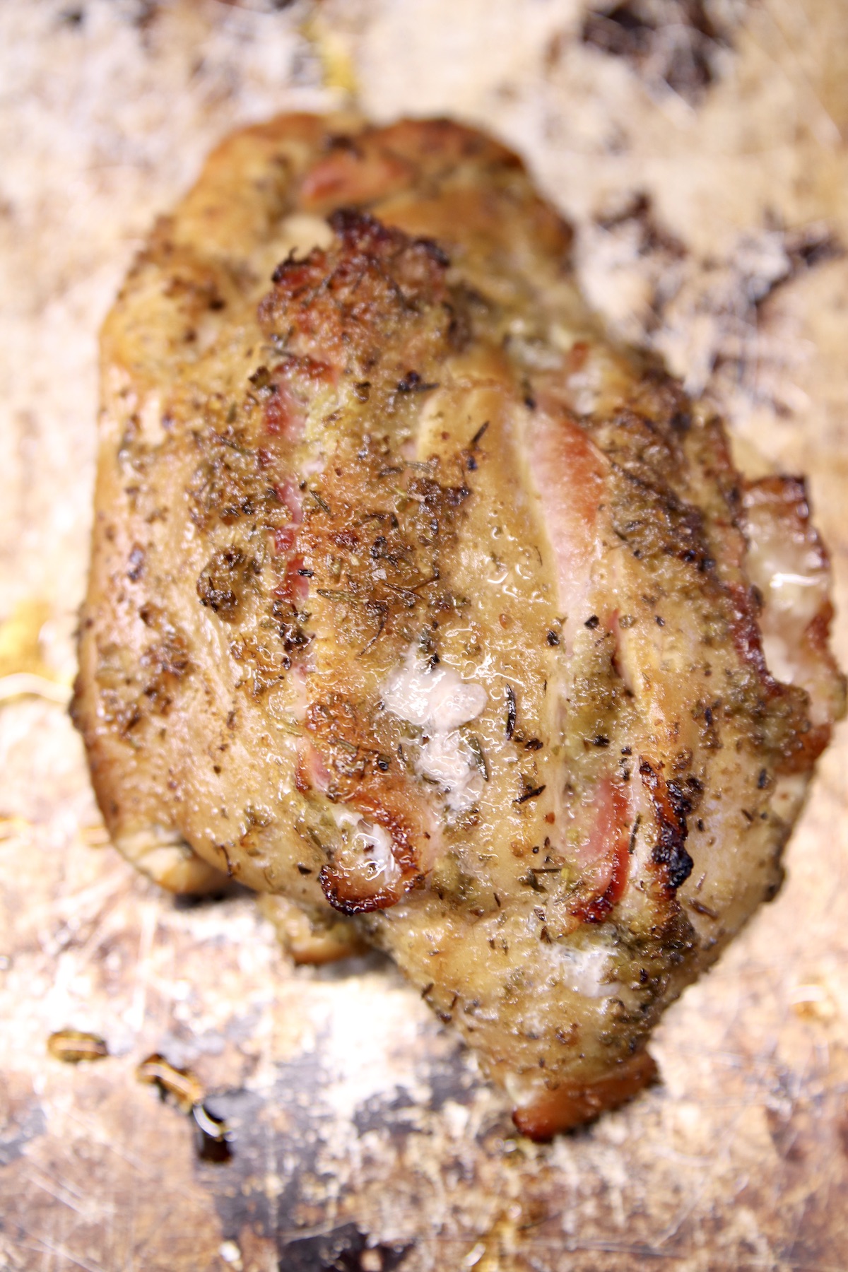 grilled chicken breast stuffed with bacon on a sheet pan
