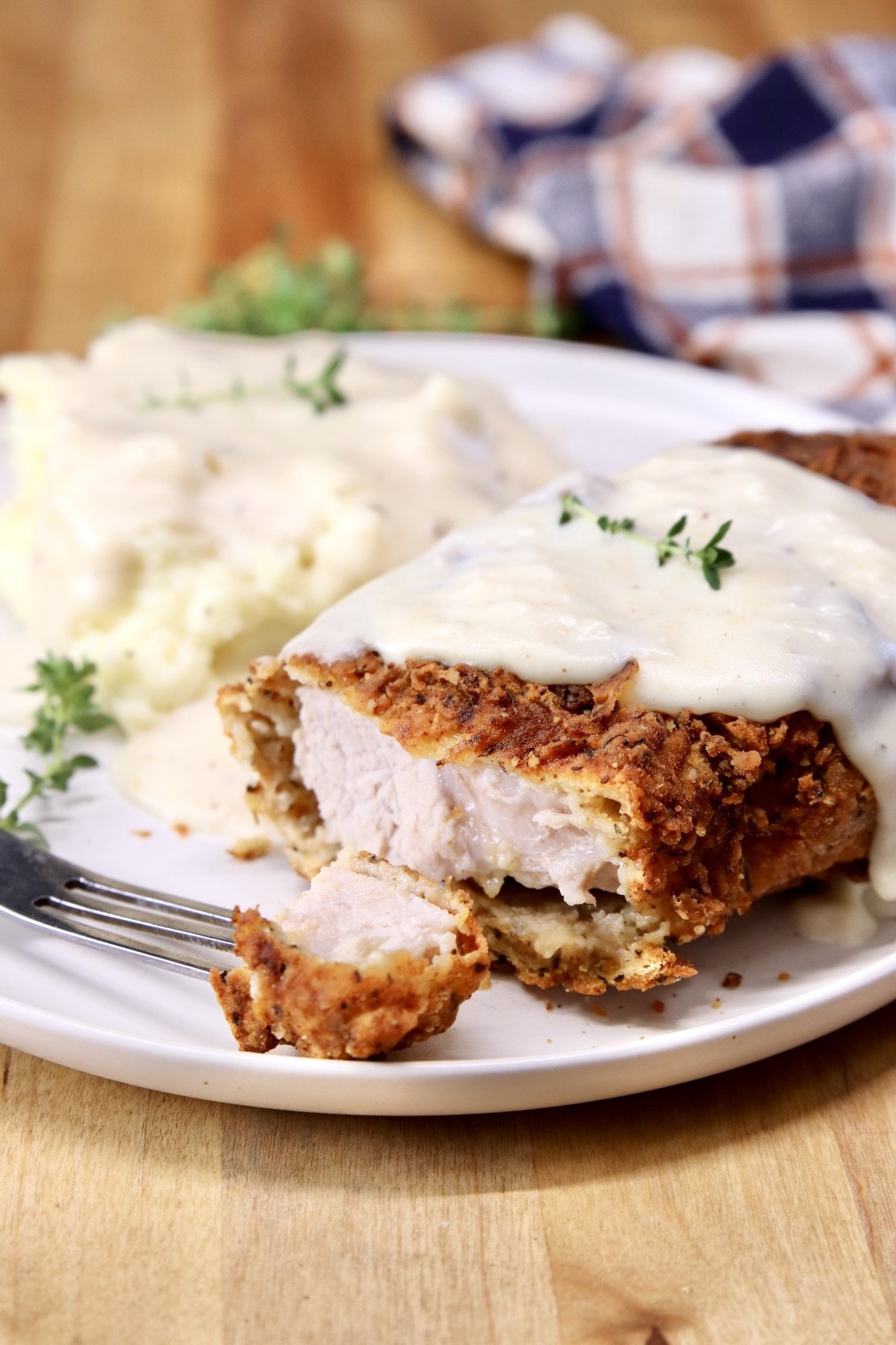 fried pork chops with bite cut off - topped with milk gravy
