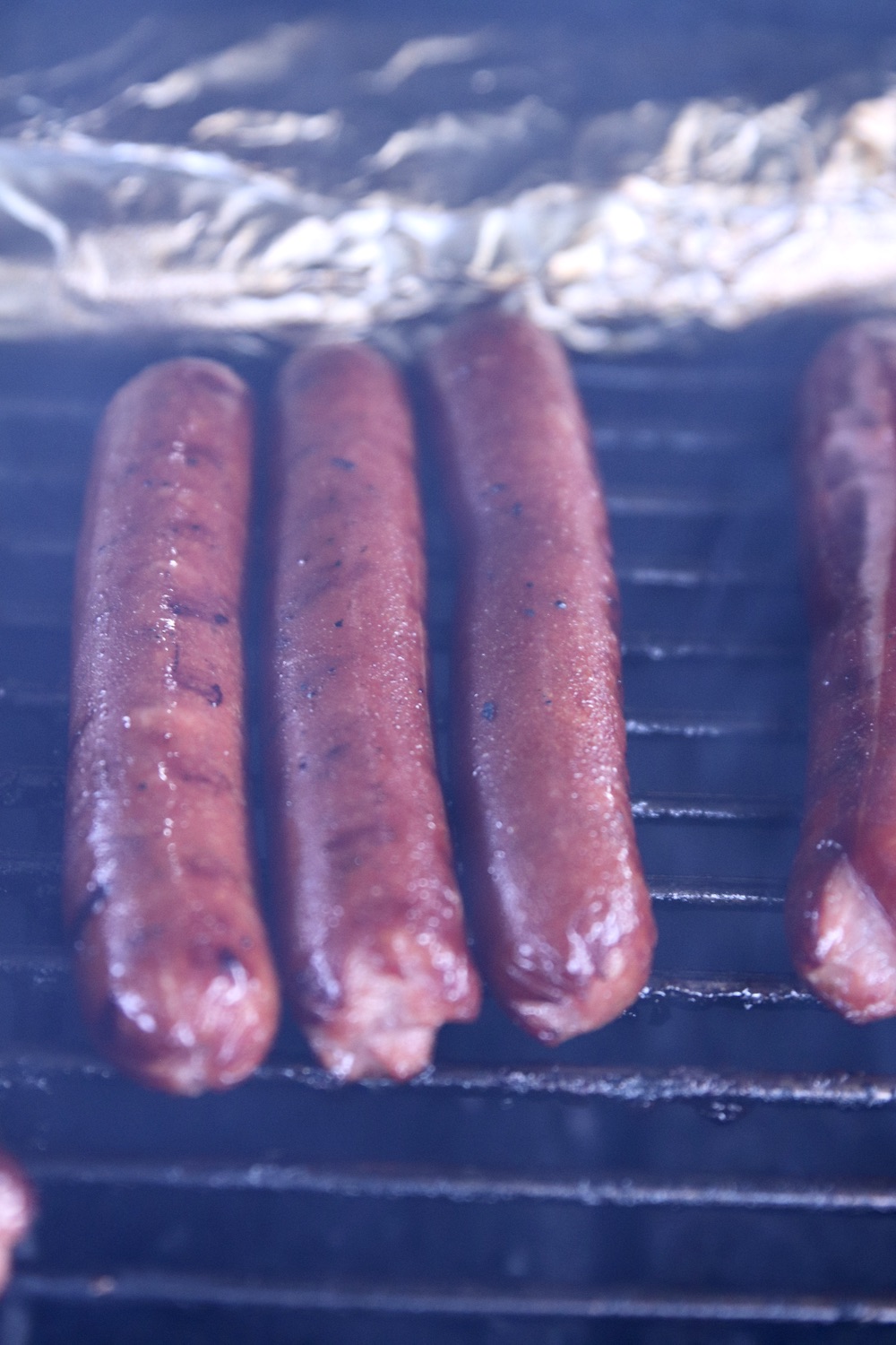 charred hot dogs on a grill