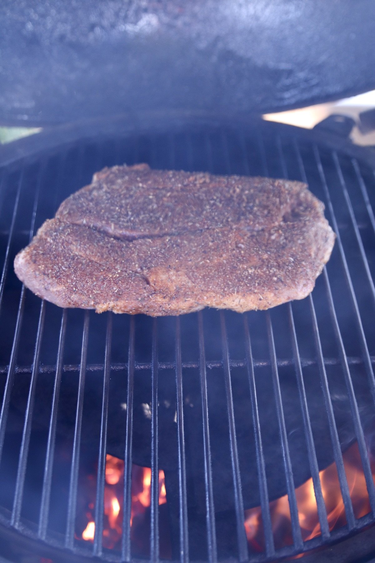 chuck roast on a grill - some flames showing thru grate