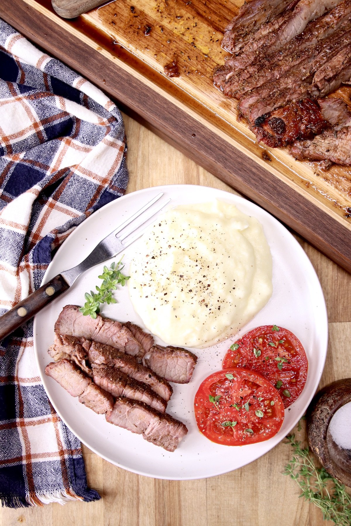 Plate of sliced roast, mashed potatoes, sliced tommatoes