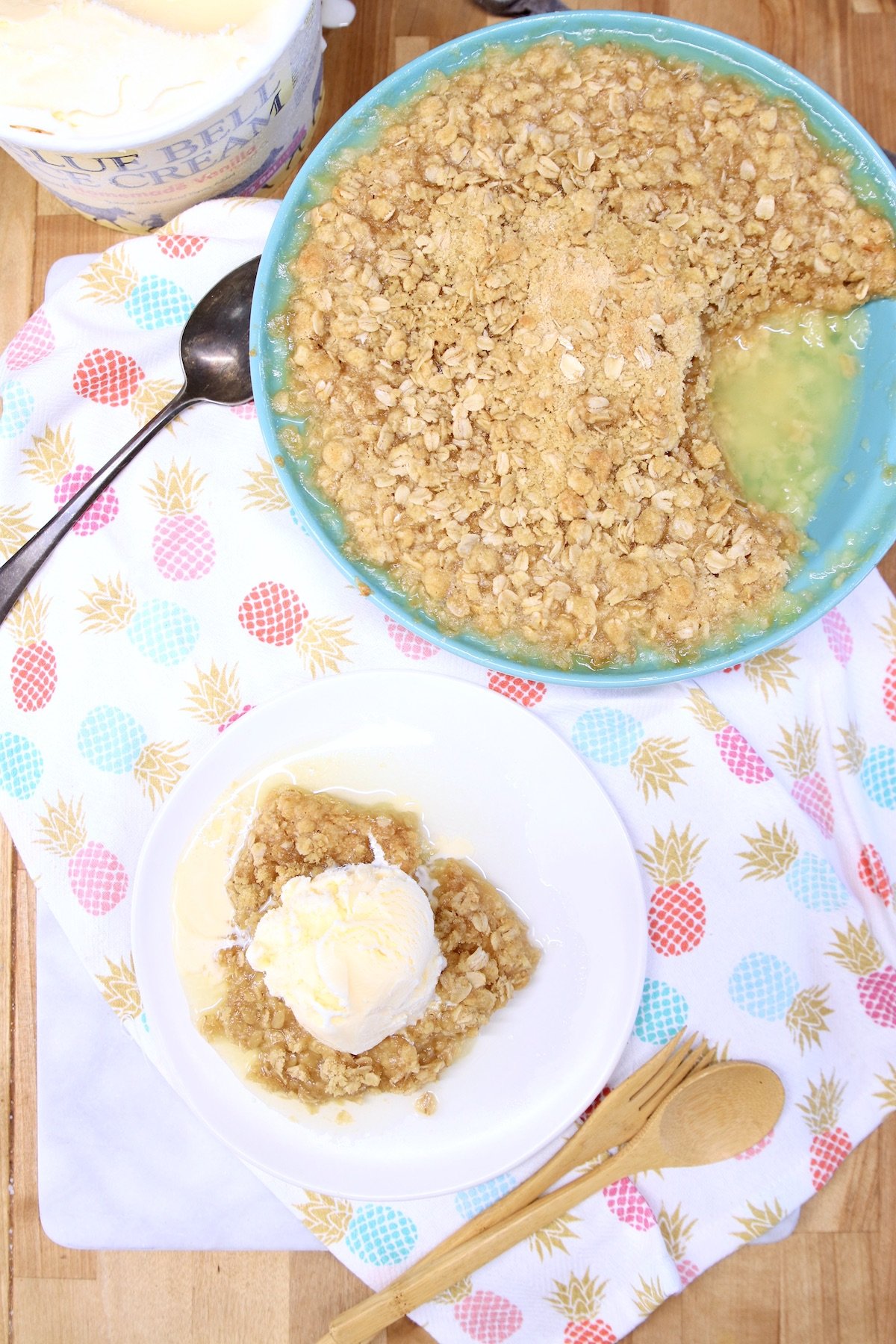 Pineapple crisp in a pie plate and served with ice cream on a saucer