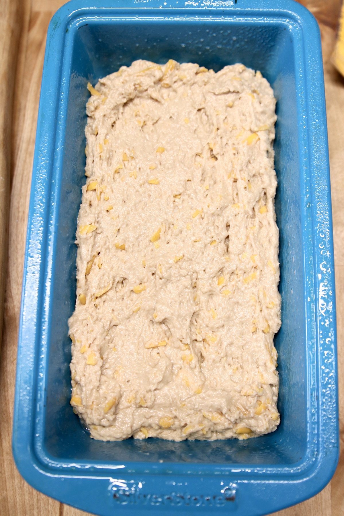 blue loaf pan filled with beer bread batter