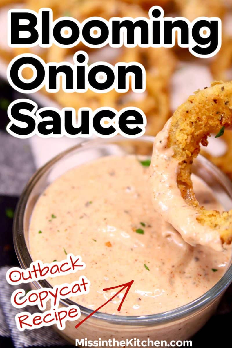 Onion ring dipping into homemade outback blooming onion sauce.