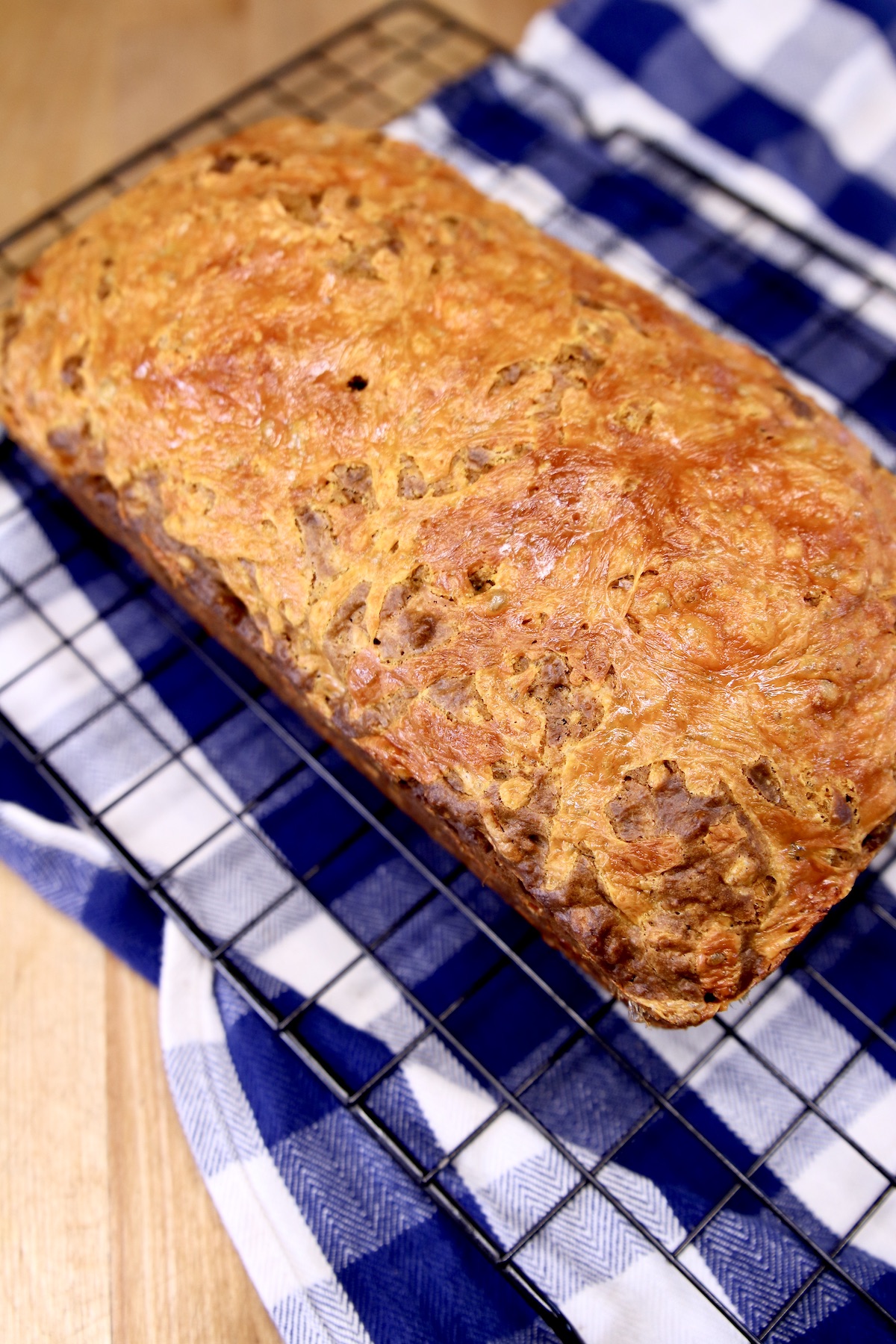 loaf of cheddar beer bread cooling on a wire rack