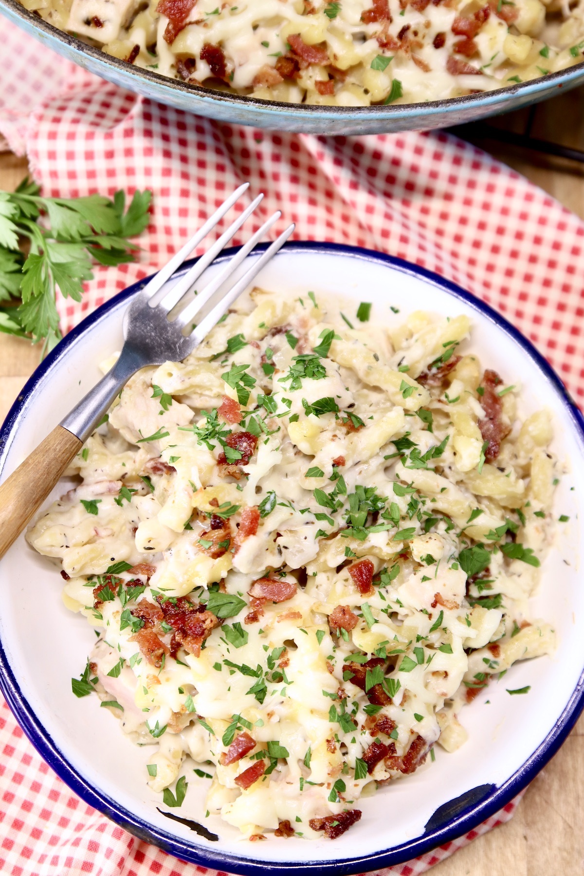 plate of chicken pasta casserole with a fork on a red check napkin