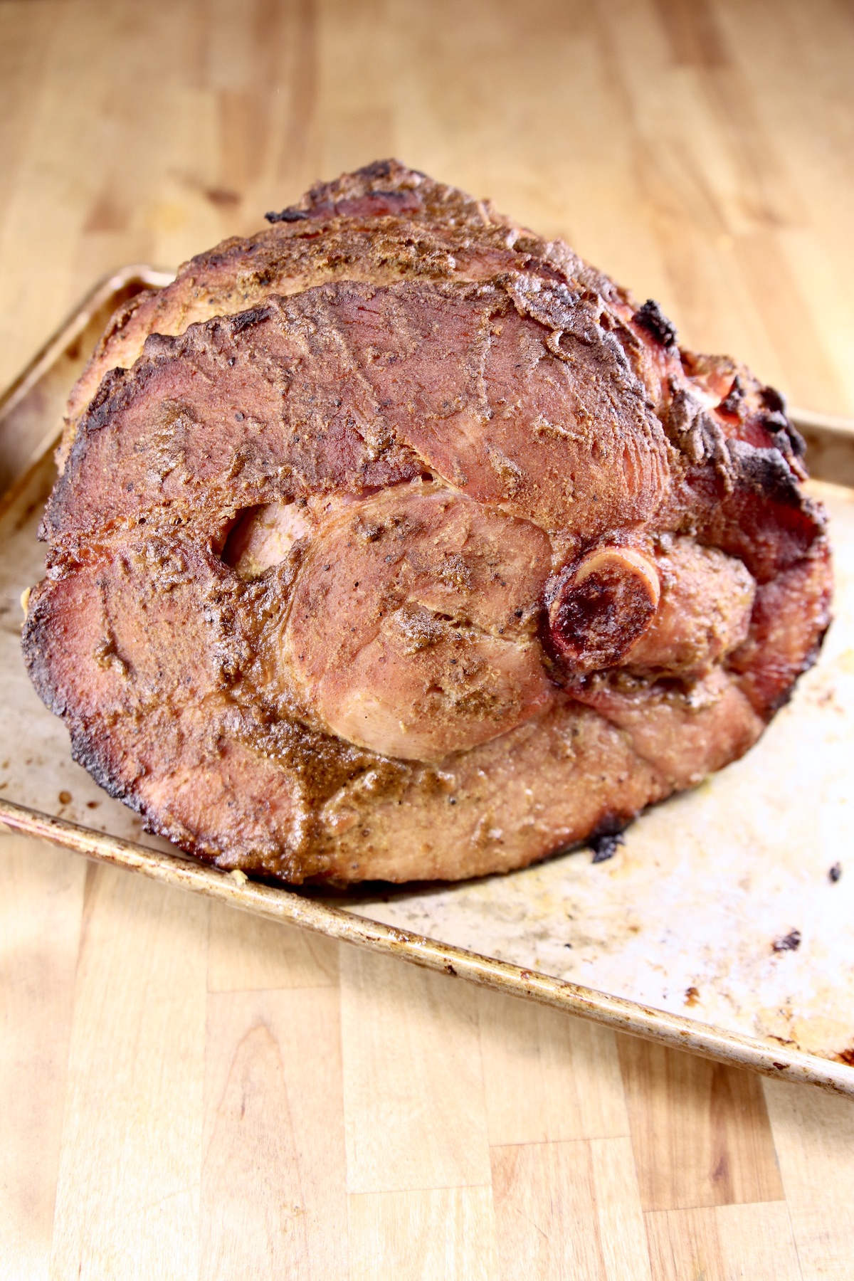 mustard glazed ham on a baking sheet