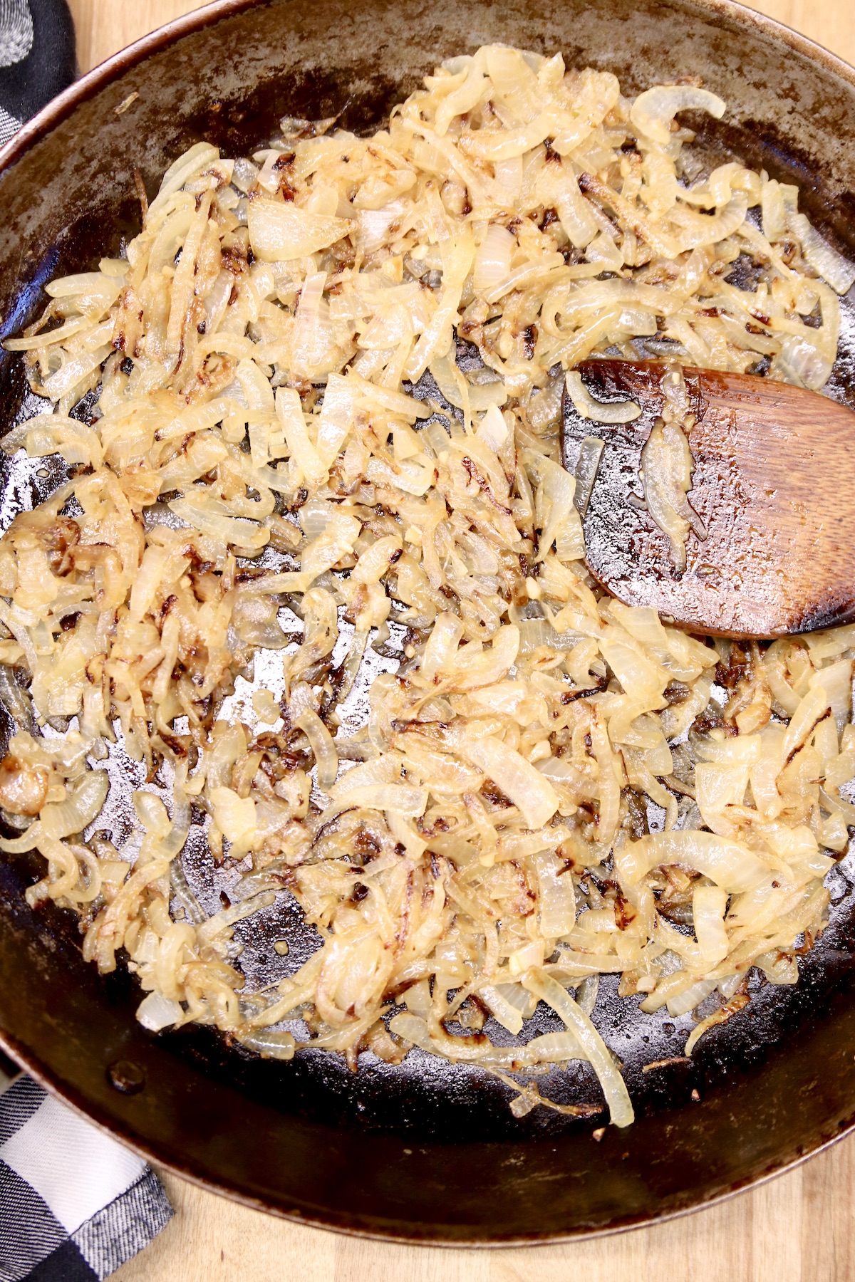 skillet with caramelized onions and wooden spoon
