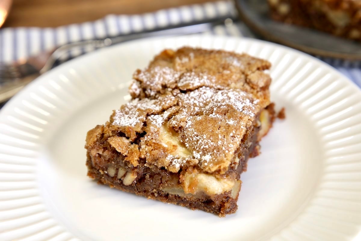 Slice of apple cake on a white plate.