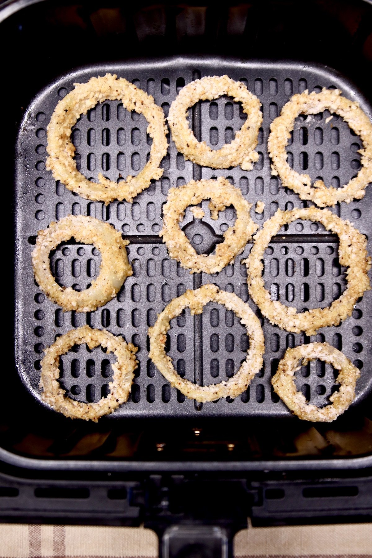 onion rings in an air fryer basket
