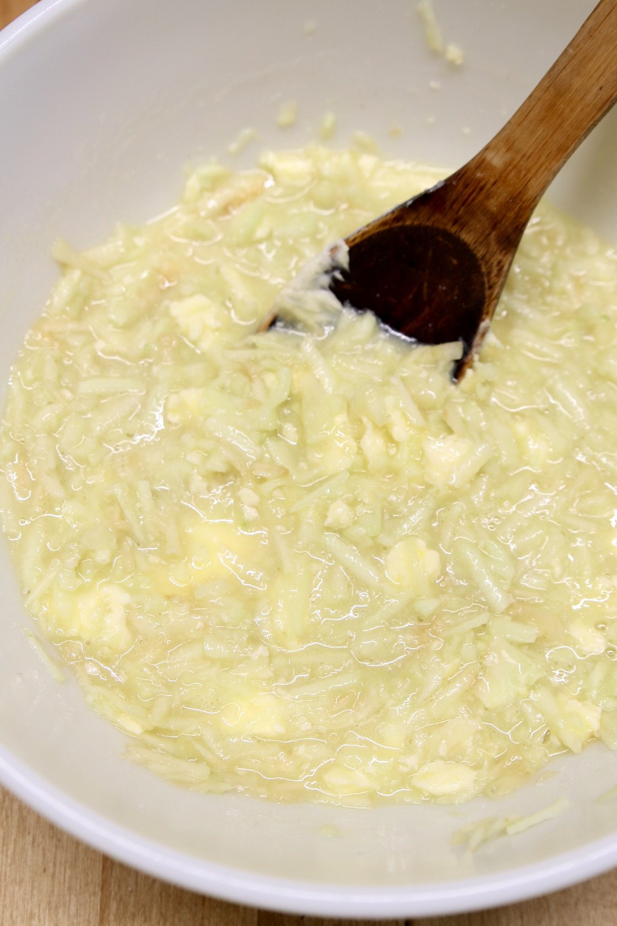 apple bread batter with shredded apples - wooden spoon