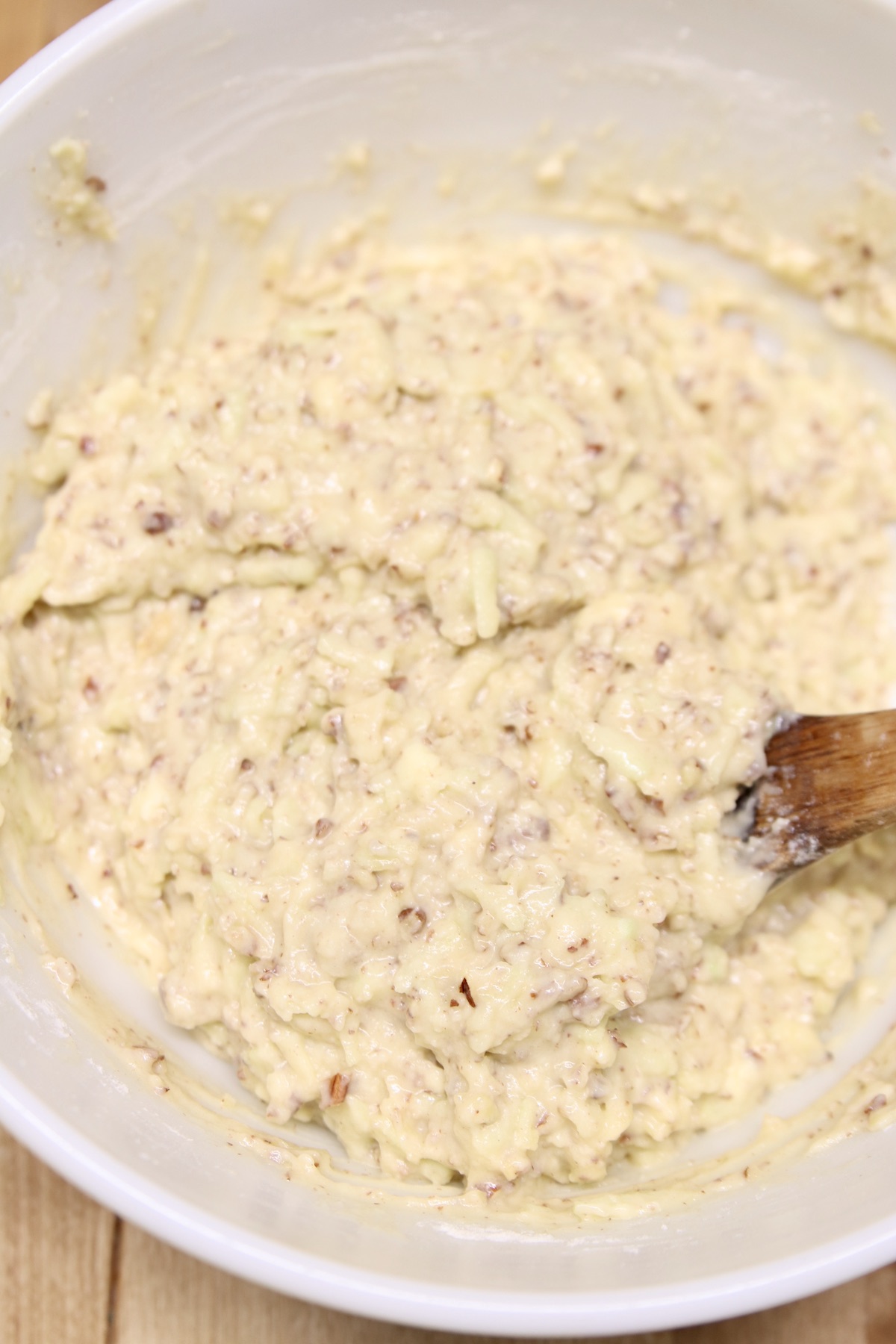 apple bread batter in a bowl with wood spoon