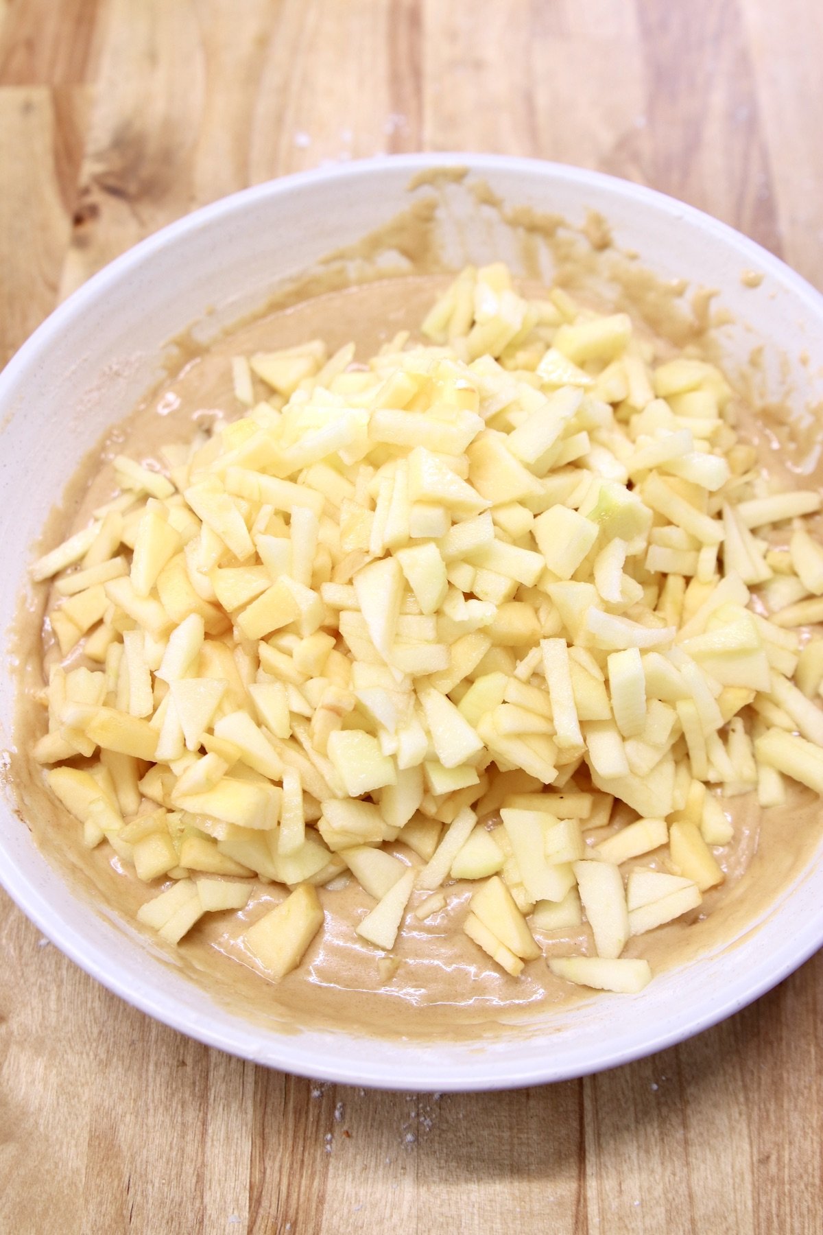 diced apples in bowl of batter