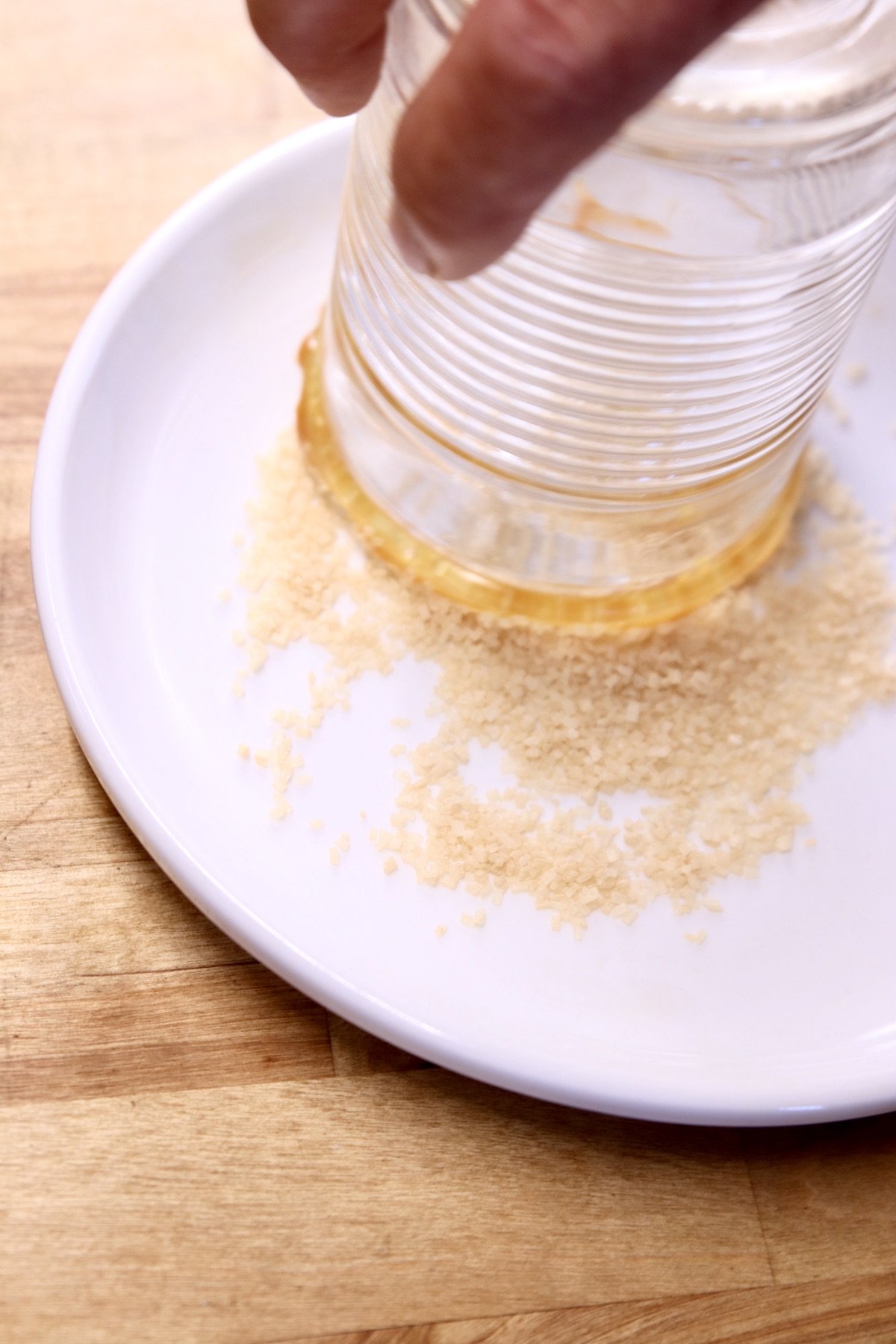 dipping cocktail glass into sugar for rim garnish