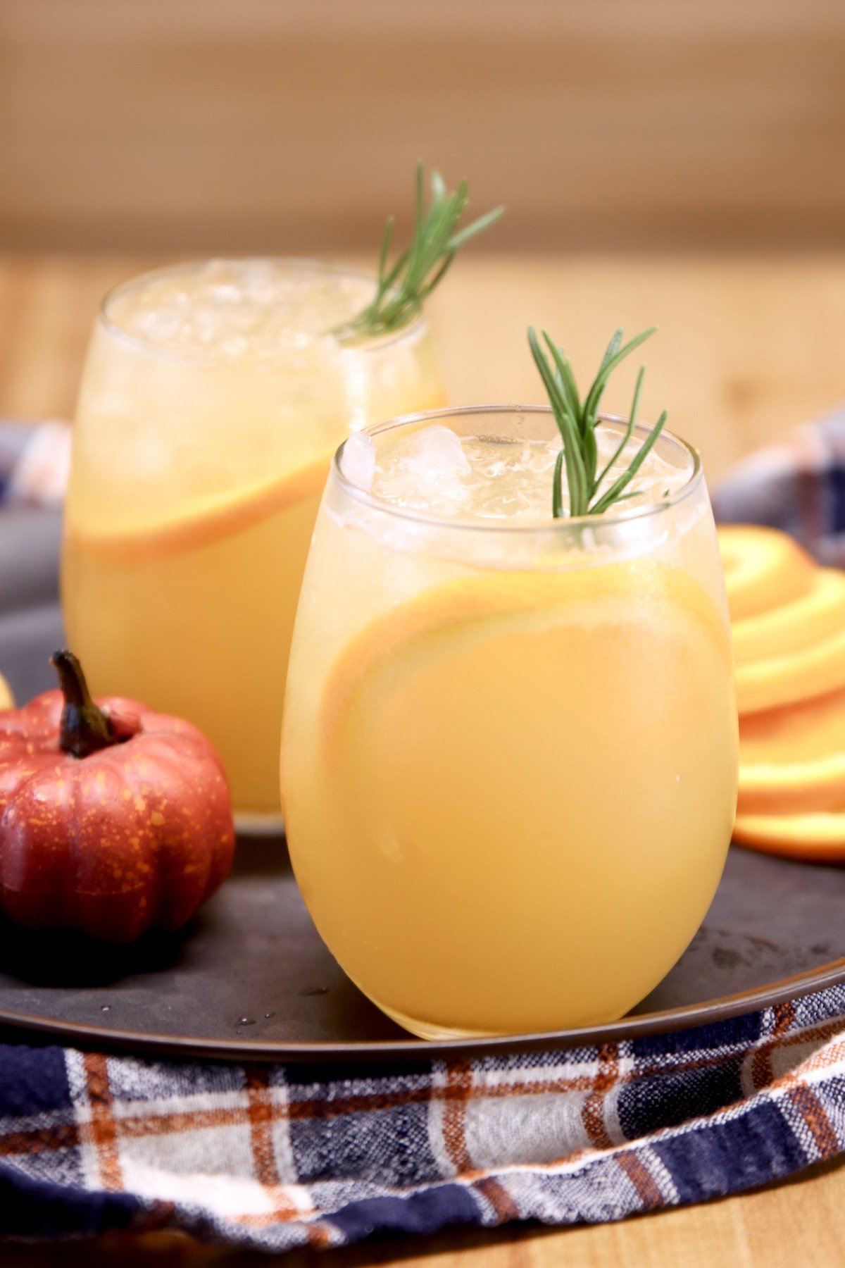 apple cider wine cocktail in a stemless wine glass - 2 on a tray