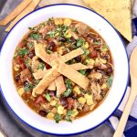 Chicken tortilla soup in a bowl topped with crispy tortilla strips