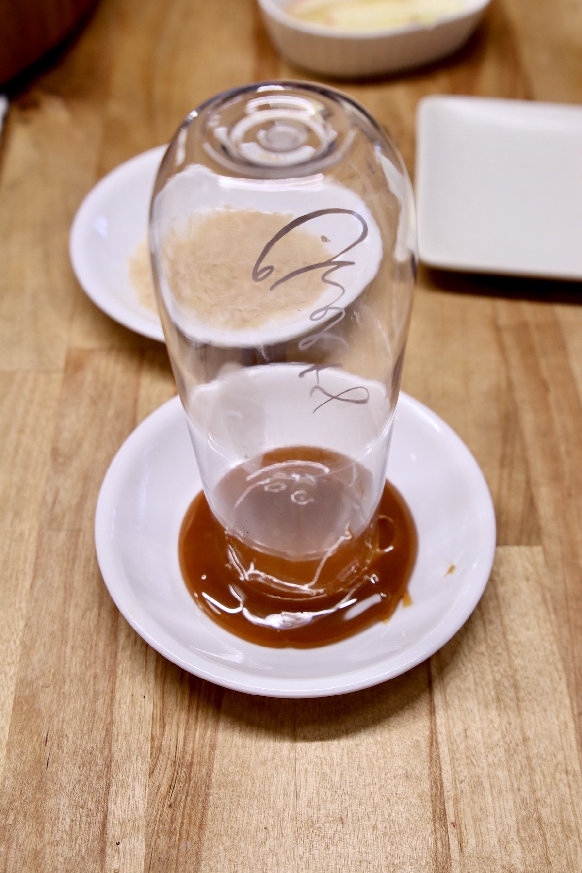 dipping champagne flute into bowl of caramel sauce