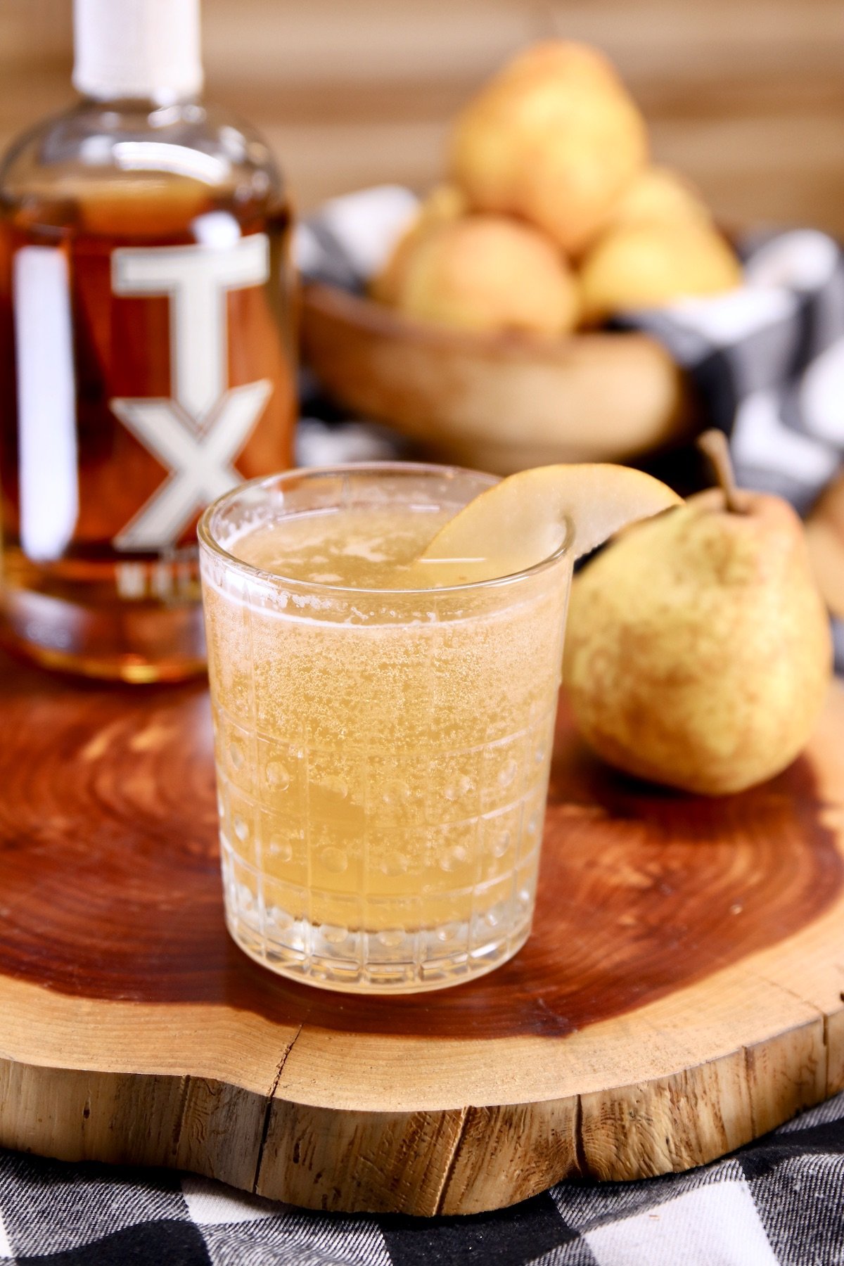 TX whiskey bottle - pear whiskey smash cocktail in a glass, whole pears to the side