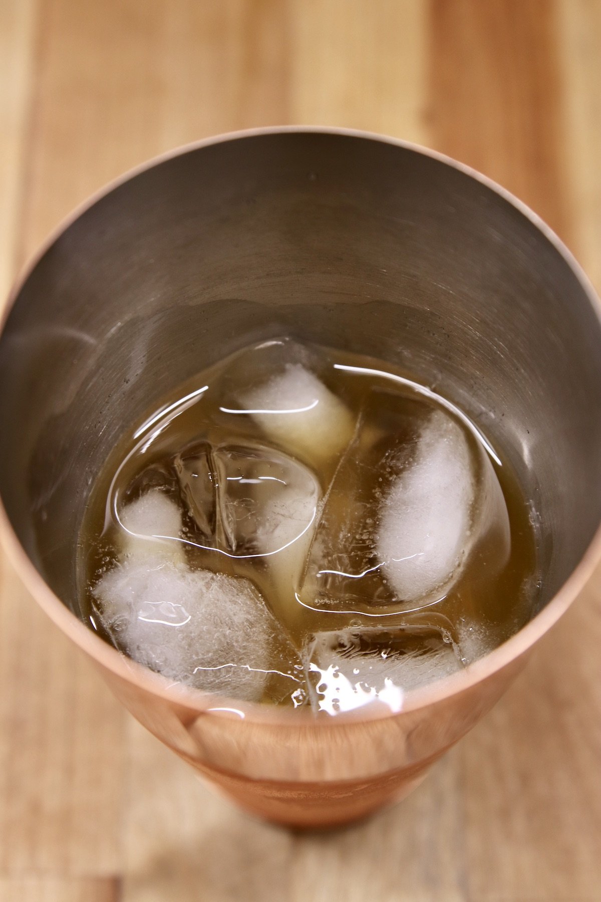 whiskey and pear juice in a cocktail shaker with ice
