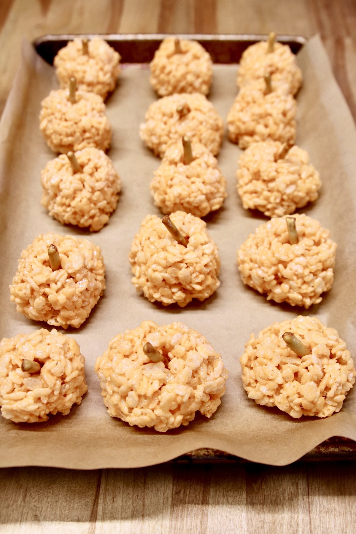 orange rice krispies balls with pretzel sticks