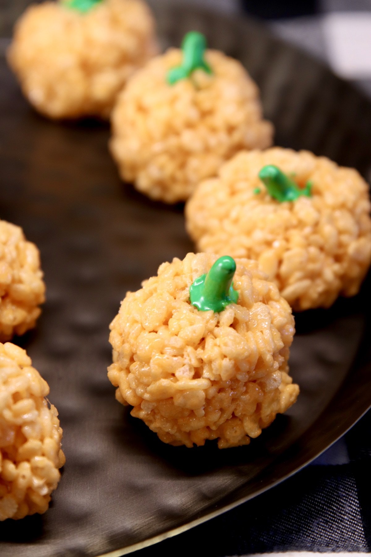 Pumpkin rice krispies treats on a black tray