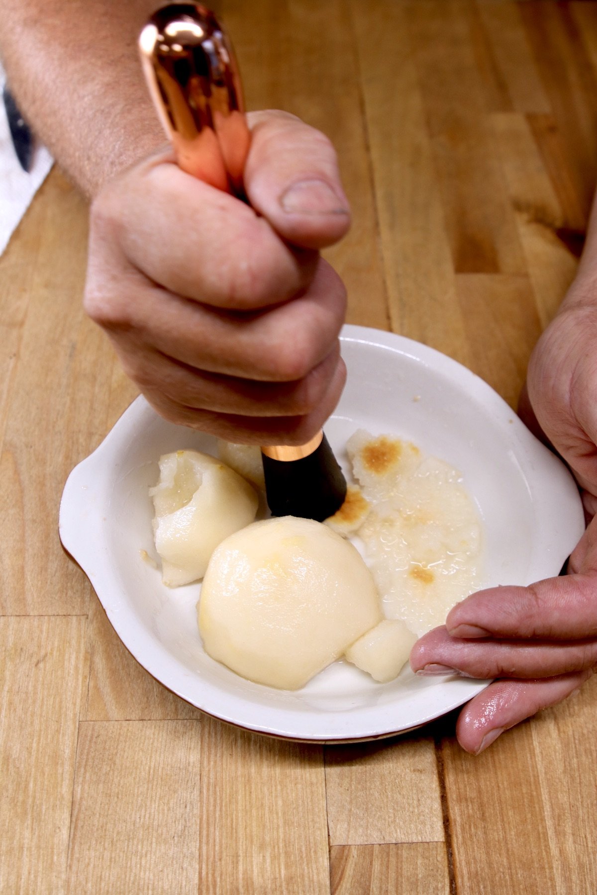 Smashing pears in a bowl to extract the juice