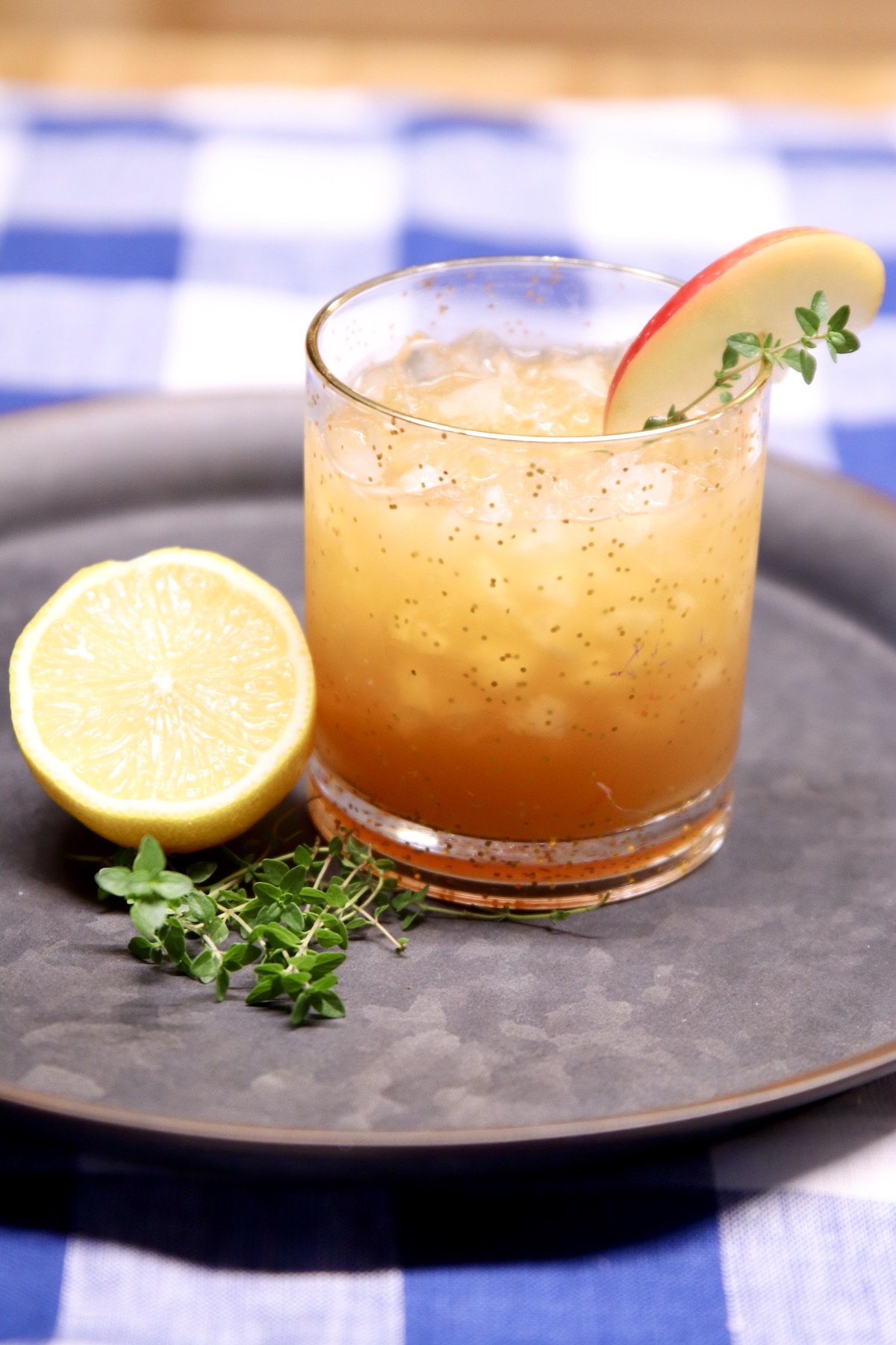 apple amaretto cocktail on a tray with half of a lemon