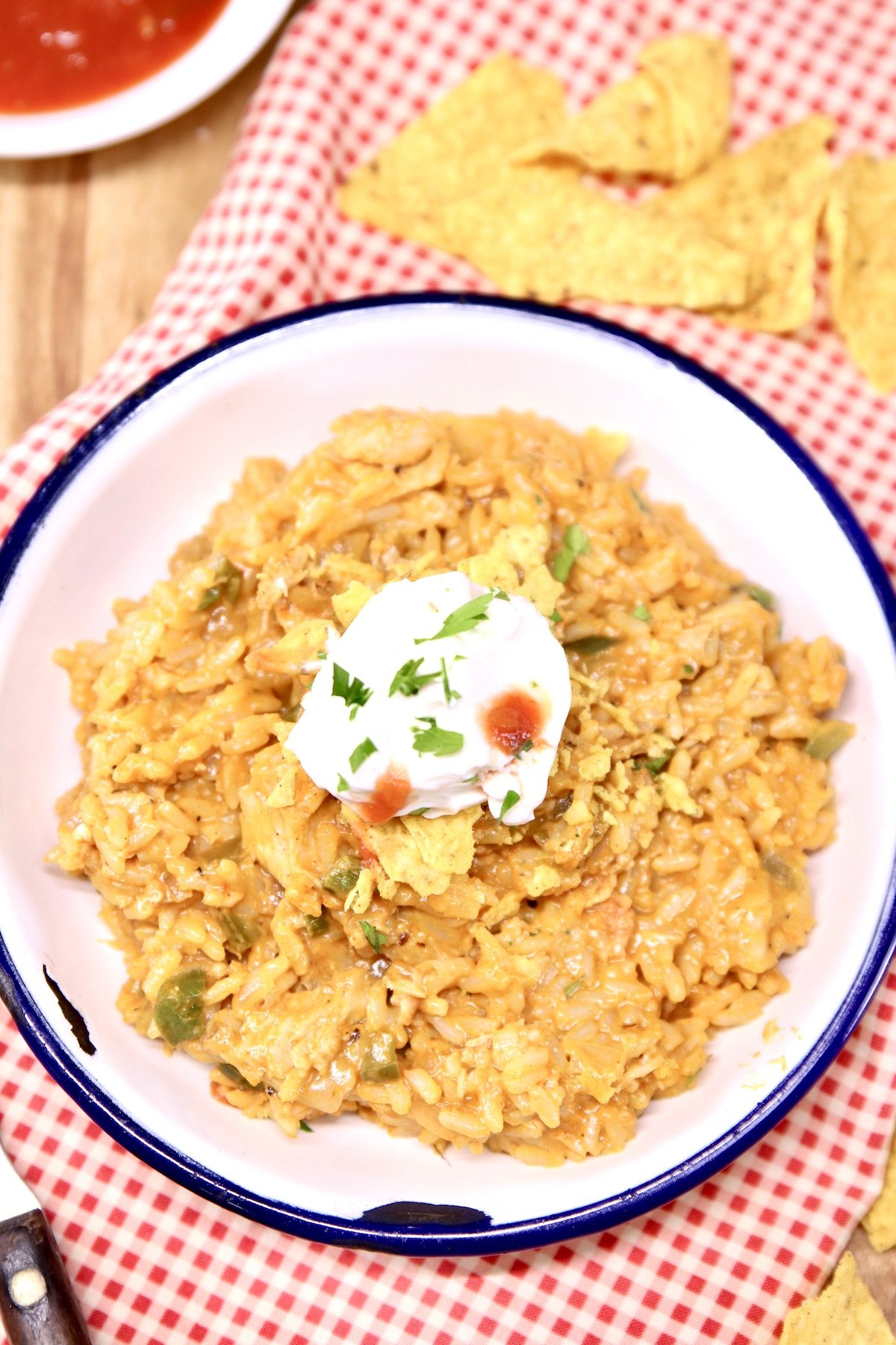 cheese chicken taco rice in a bowl with sour cream and salsa