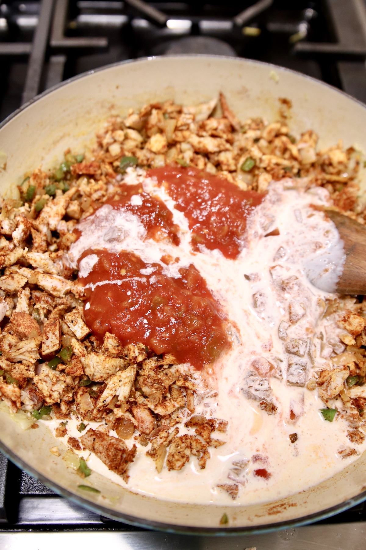 salsa and cream added to chicken in a pan