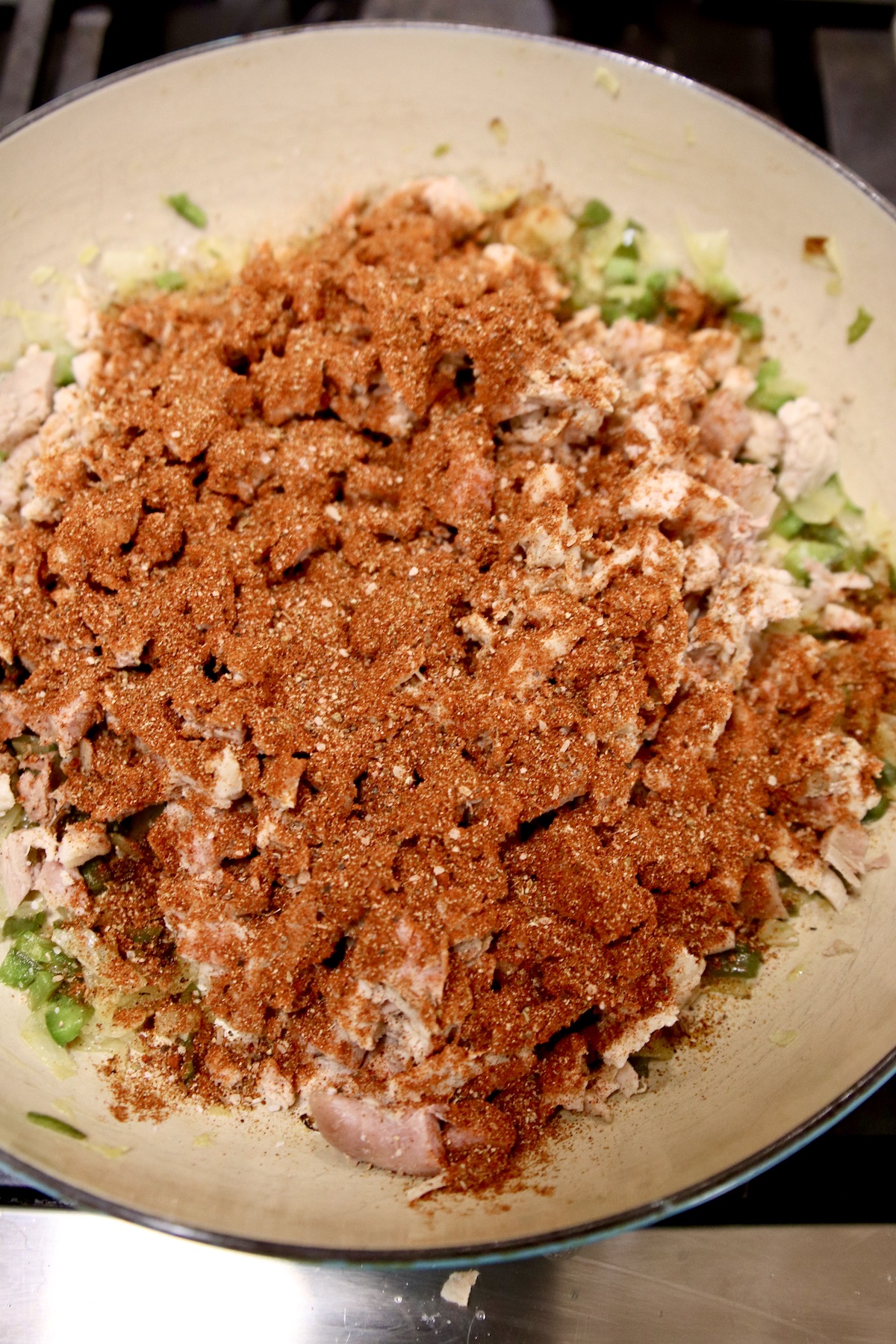 taco seasoning added to chicken skillet