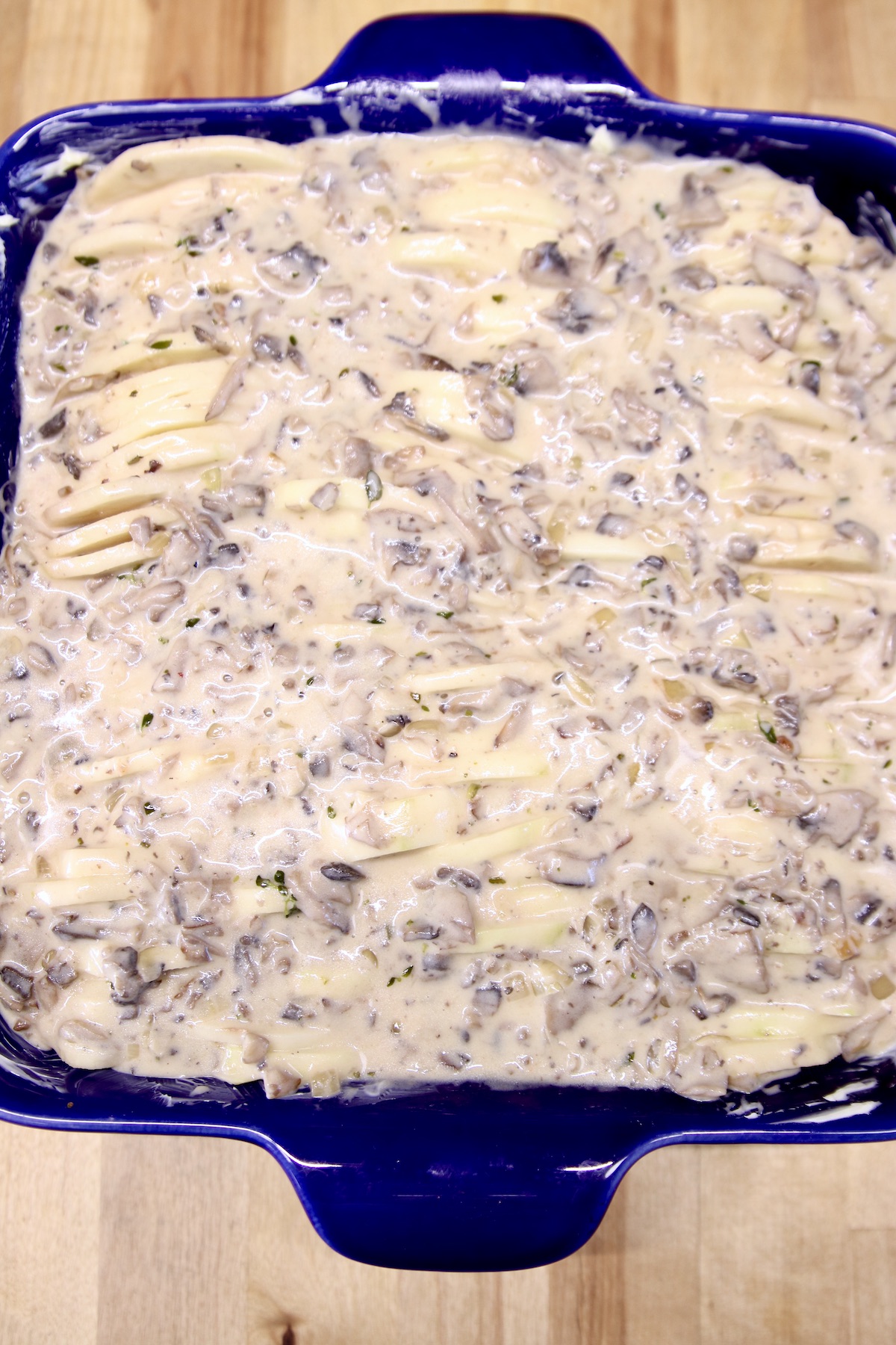 cream of mushroom soup over potatoes in a casserole dish