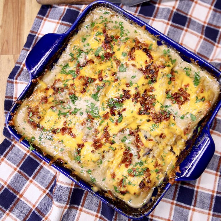 potato casserole with cheese and bacon in a blue square baking dish