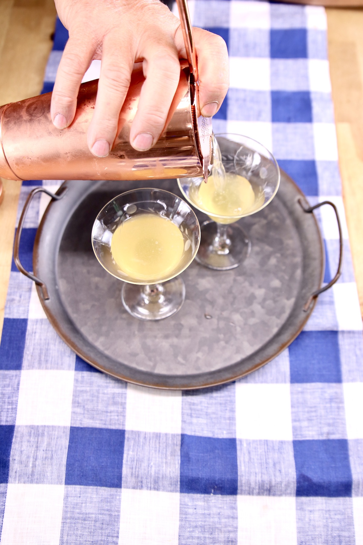 pouring daisy cocktail into coupe glasses