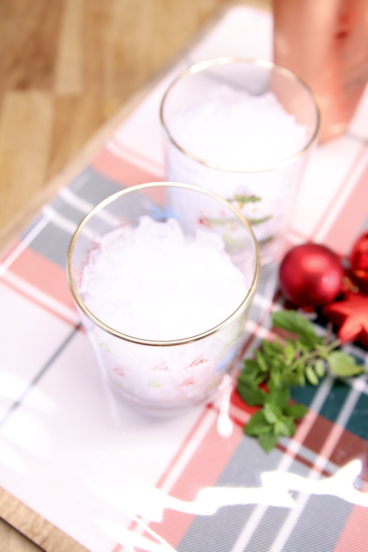2 cocktail glasses with crushed ice on a holiday platter