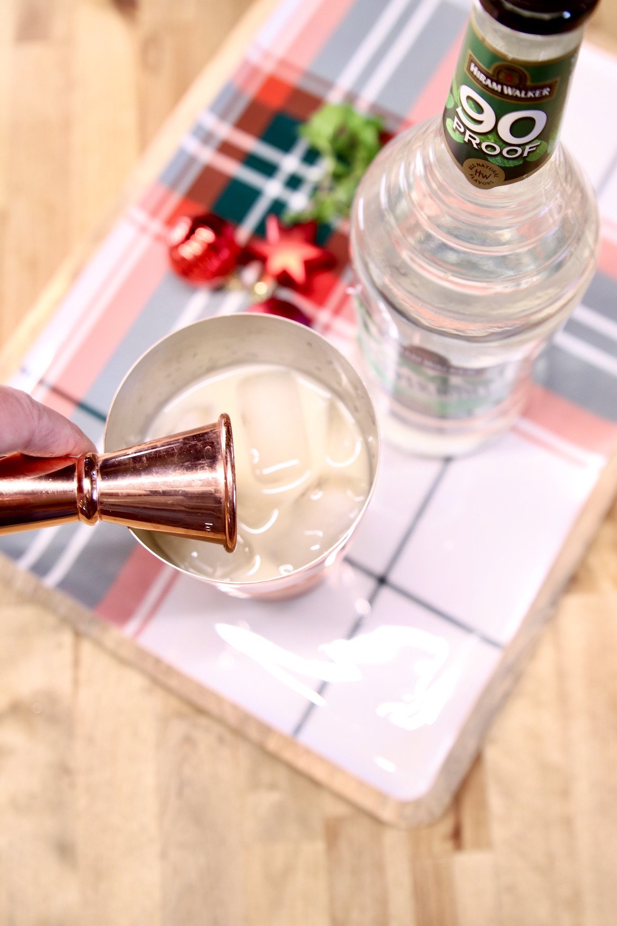 adding peppermint schnapps into a cocktail shaker