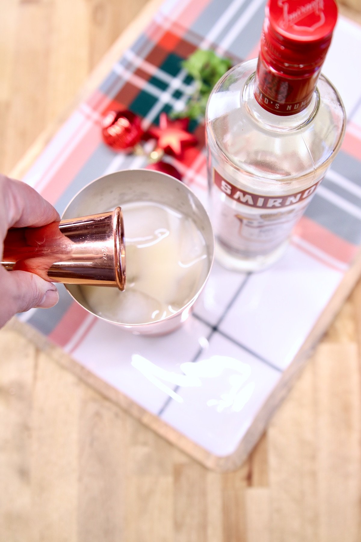 adding vodka to a cocktail shaker
