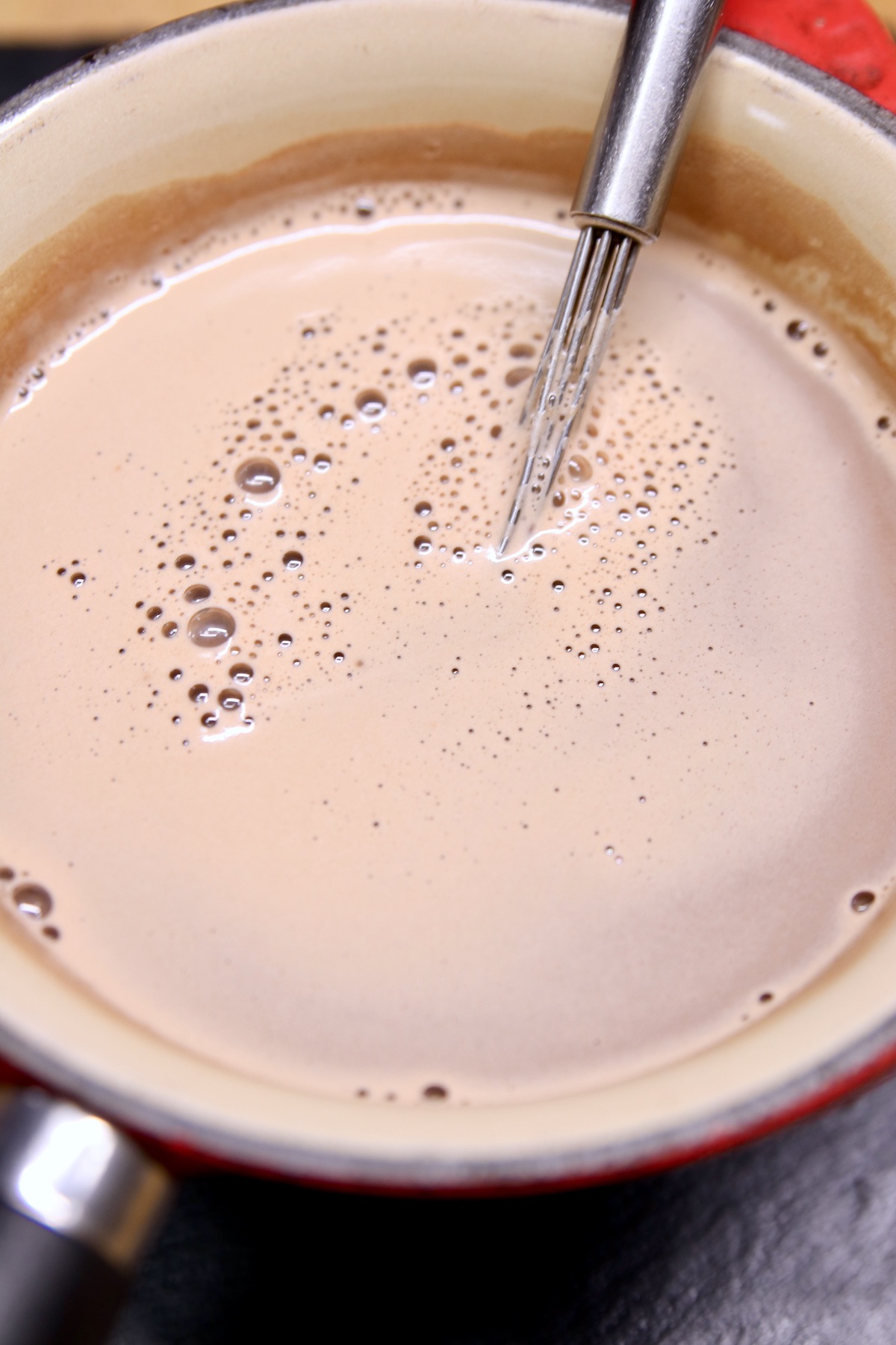hot chocolate in a saucepan with whisk