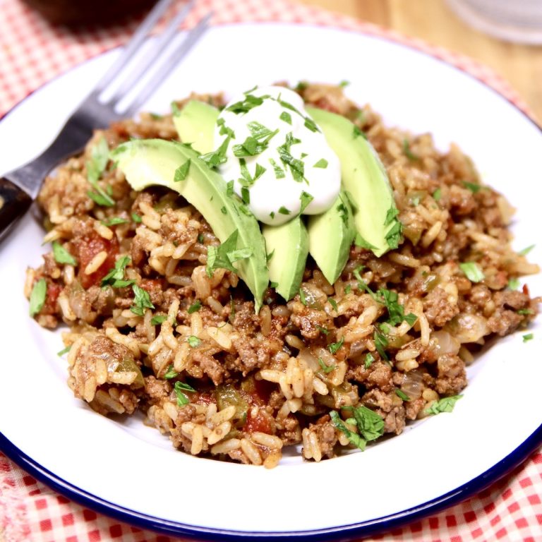 Spanish Rice with Ground Beef topped with sour cream, avocado slices and cilantro