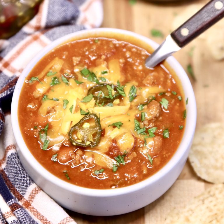 venison chili in a bowl topped with cheese and jalapeno slices
