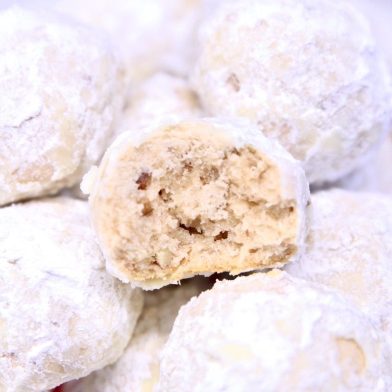 Snowball Cookies on a platter - one bit in half