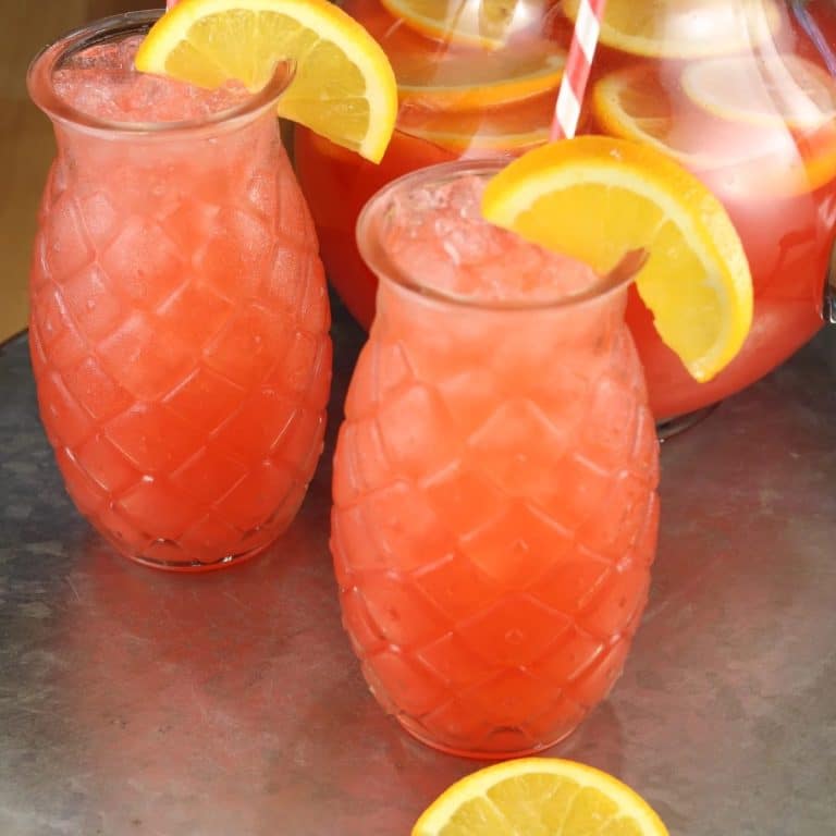 2 glasses of vodka punch in pineapple shaped glasses.