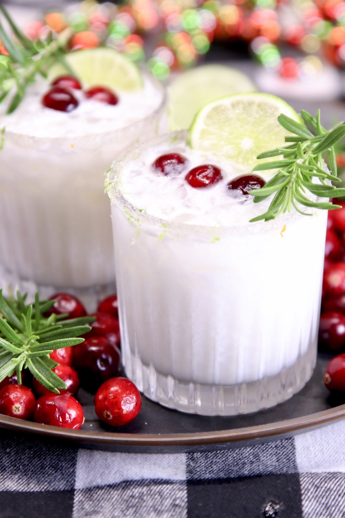 white Christmas margaritas with cranberry and rosemary garnish